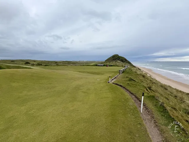 Golfers on a tee at Royal Portrush, with the Atlantic behind them.