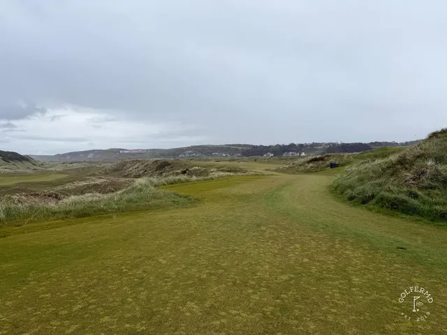 A fairway at Royal Portrush with a bunker on the right and the water ahead.