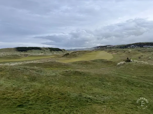 A tee shot at Royal Portrush, the fairway dropping toward a green above the beach.