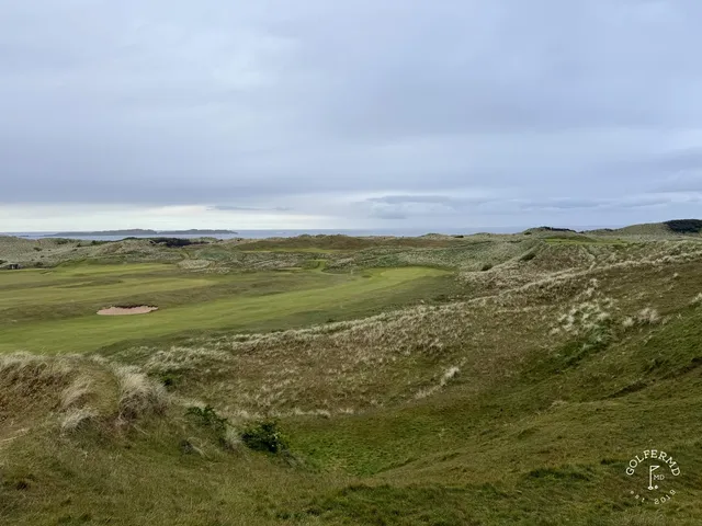 The coastline and the links at Royal Portrush under a cloudy sky.