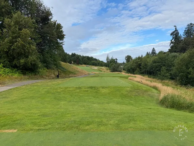 A wide view at Salish Cliffs, the hole set among tall trees.