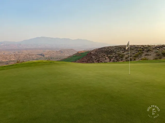A green and flagstick at Sand Hollow, with a bunker short of the hole and the desert behind.