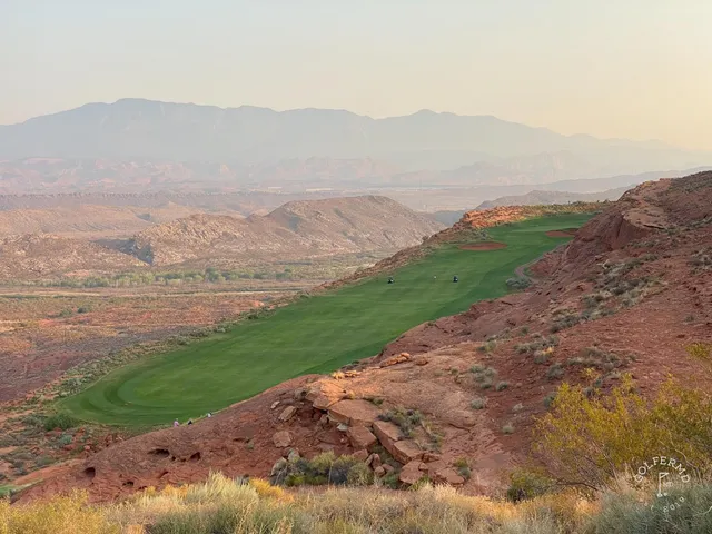 The red cliffs rising behind a fairway at Sand Hollow.