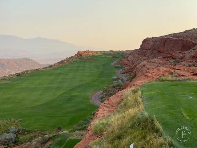 A wide fairway at Sand Hollow, red cliffs on the right and the green in the distance.