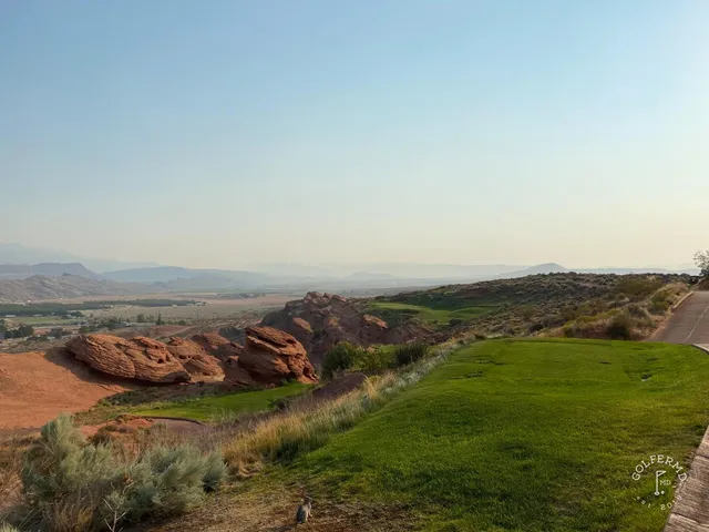 A wide desert panorama at Sand Hollow, several holes set against the cliffs.