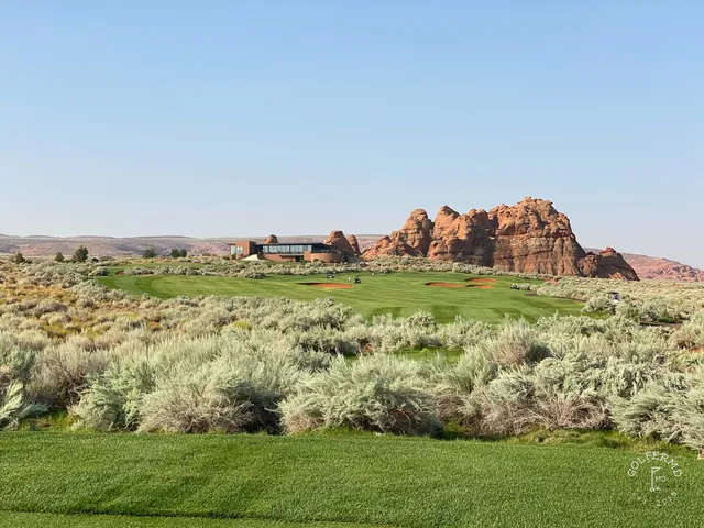 A green at Sand Hollow on the edge of the desert, the flagstick against the red rock.