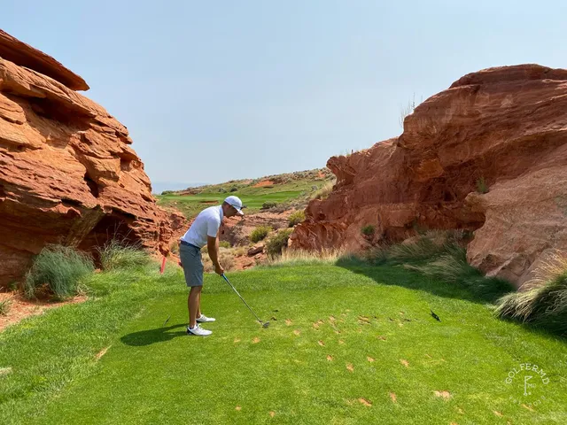 A wide hole at Sand Hollow with water visible and the red rock on the horizon.