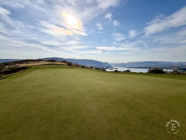 A green at Scarecrow guarded by sand, the hole short and the hills beyond.