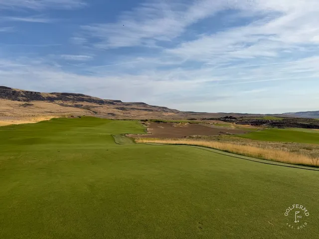 A golfer putting at Scarecrow, with sandy ground around the green.