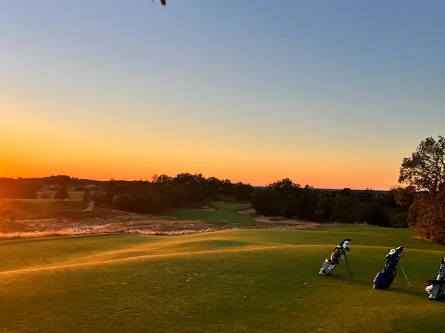 A green and flagstick at Sedge Valley, seen from the fairway, with bunkers around the hole.