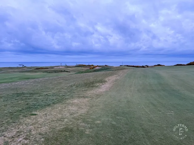 A green at Sheep Ranch set on the edge of the bluff, the flagstick against the water.