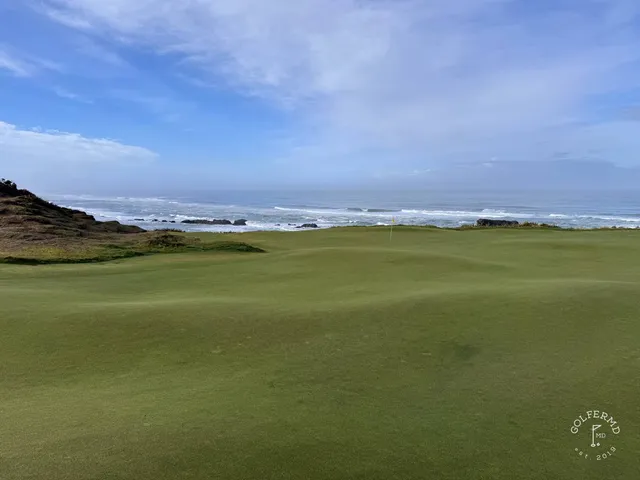 A green at Sheep Ranch guarded by sand, with the coastline behind the hole.