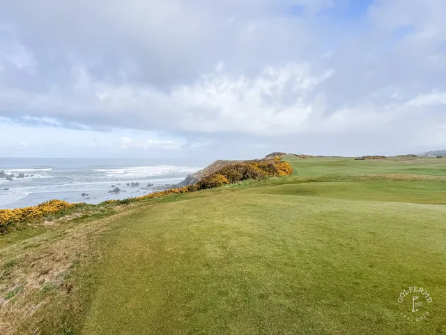 The coastline at Sheep Ranch under a cloudy sky, the course open to the wind.