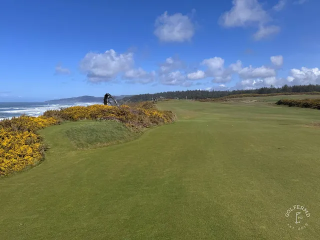 A golfer hitting an approach at Sheep Ranch, with the bluff behind the green.