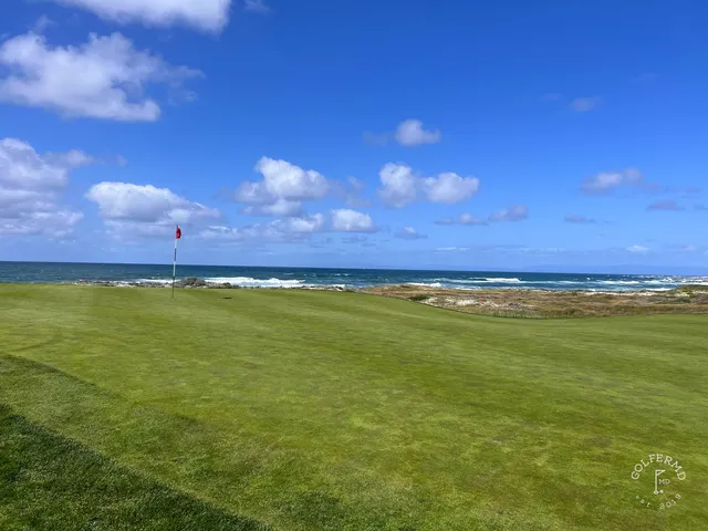 A fairway through the dunes at The Links at Spanish Bay, with the ocean beyond.