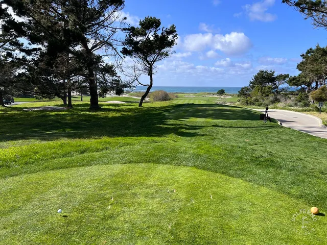 A green and flagstick above the ocean at The Links at Spanish Bay.