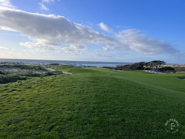A fairway and green in the dunes at The Links at Spanish Bay, with the ocean beyond.