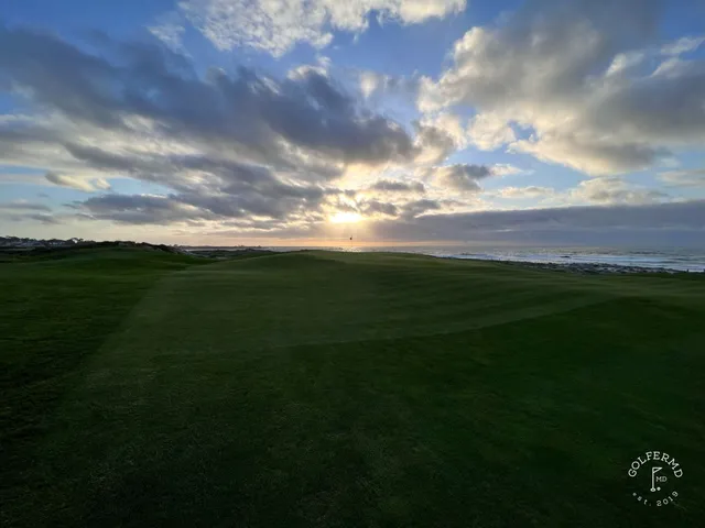 A fairway and green in the dunes at The Links at Spanish Bay, with the ocean beyond.