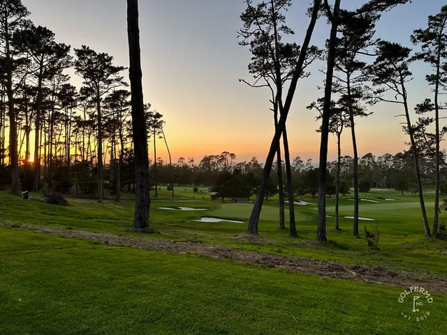 A green and flagstick above the ocean at Spyglass Hill Golf Course, with a bunker in front.