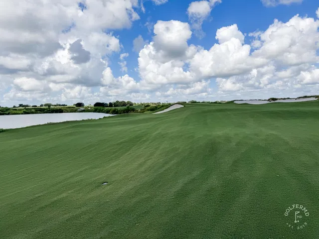 A fairway at the Blue Course winding through sand and long grass toward a green.