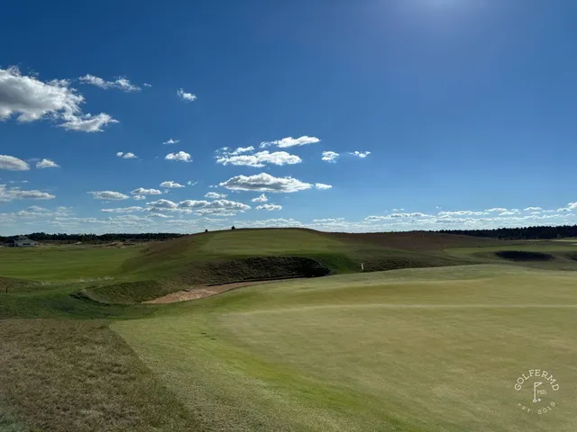 A close flagstick at The Lido, bunkers crowding the green.