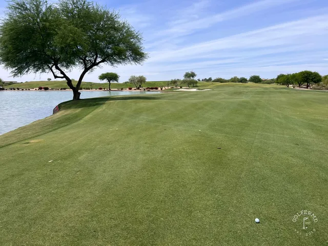 A fairway at TPC Scottsdale running toward the McDowell Mountains, with desert plants along the edges.