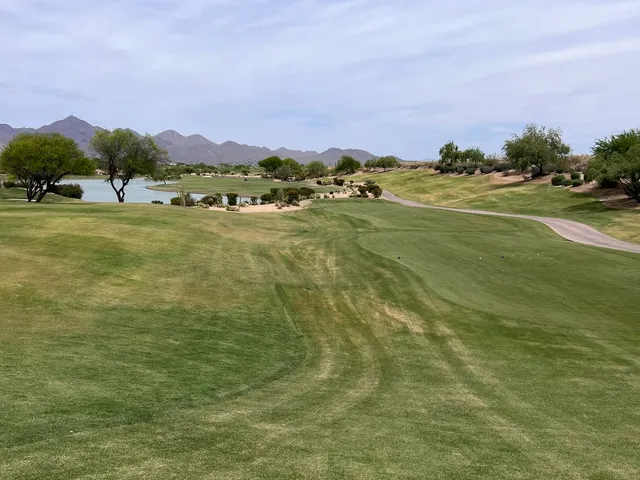 A fairway leading to a green at TPC Scottsdale, with the McDowell Mountains on the horizon.