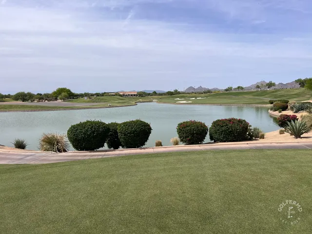 A golfer putting on a green at TPC Scottsdale, with the McDowell Mountains behind the hole.