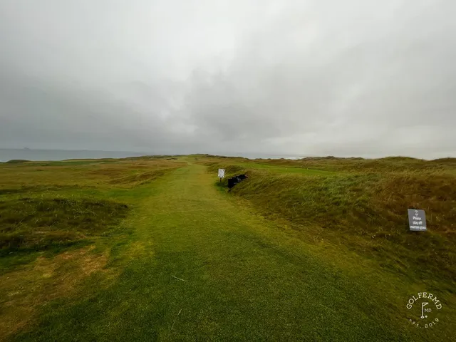 A green at Tralee set above the beach, with the flagstick and the bay beyond.