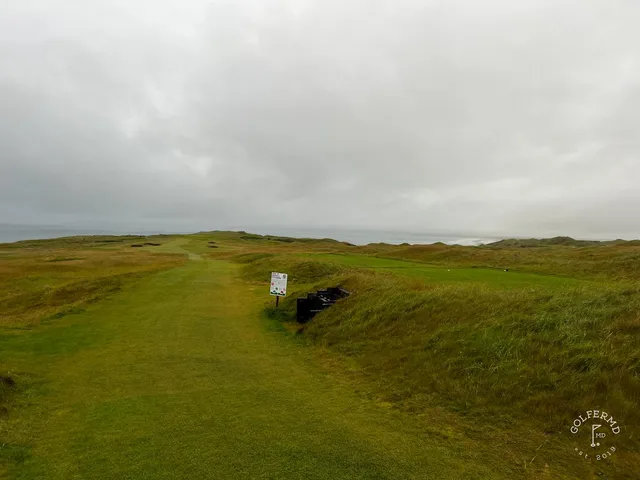 Golfers on a tee at Tralee, with the Atlantic behind them.