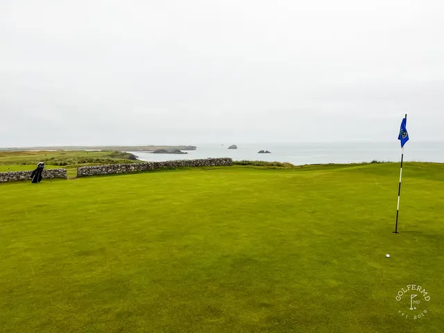 An elevated view across Tralee, fairways and bunkers in front of the ocean.