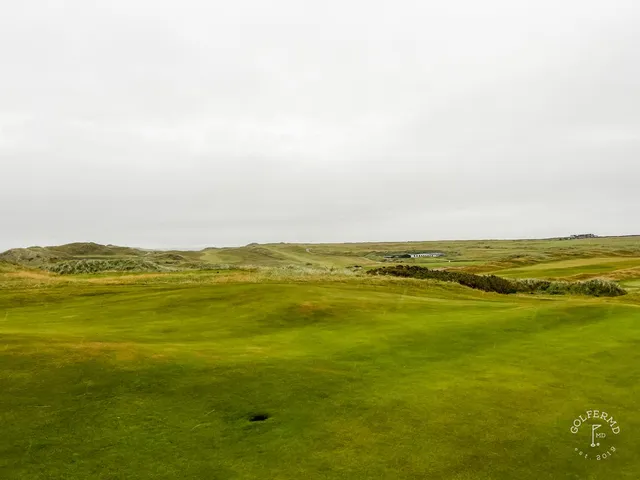 A tee shot at Tralee, the fairway dropping toward a green above the beach.
