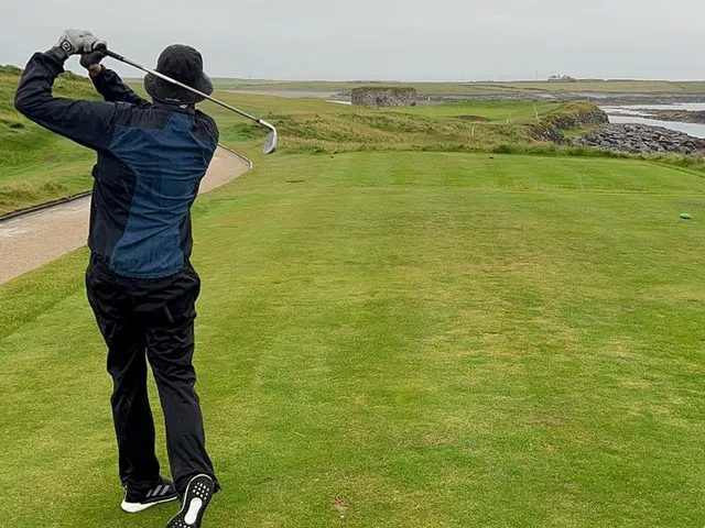 A close view of a green at Tralee, the flagstick framed by marram grass.