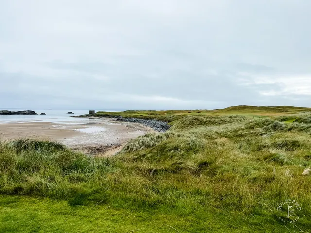 A fairway at Tralee from the tee, bunkers on both sides and the ocean ahead.
