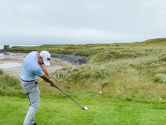 A green and bunker at Tralee, the flagstick against the ocean.