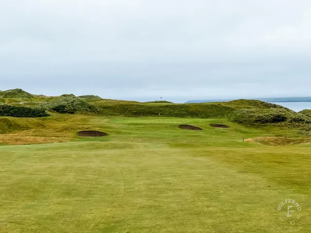 A turning fairway at Tralee, bending left toward the ocean.