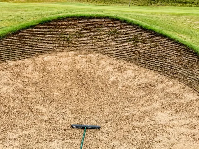 A pot bunker in the foreground at Tralee, with the green and the Atlantic beyond.