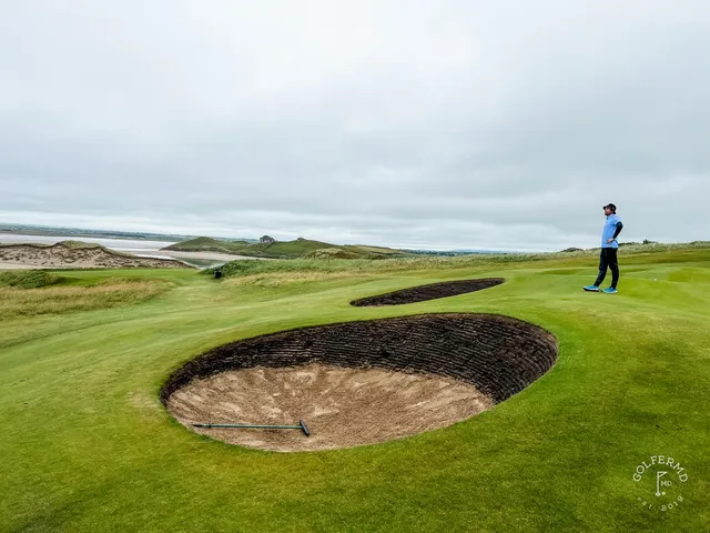 A flagstick at Tralee against the sky, the green falling toward the sea.