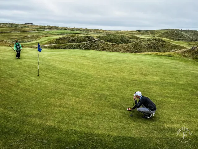 Sand in the foreground at Tralee, with the flagstick on the green beyond the bunker.