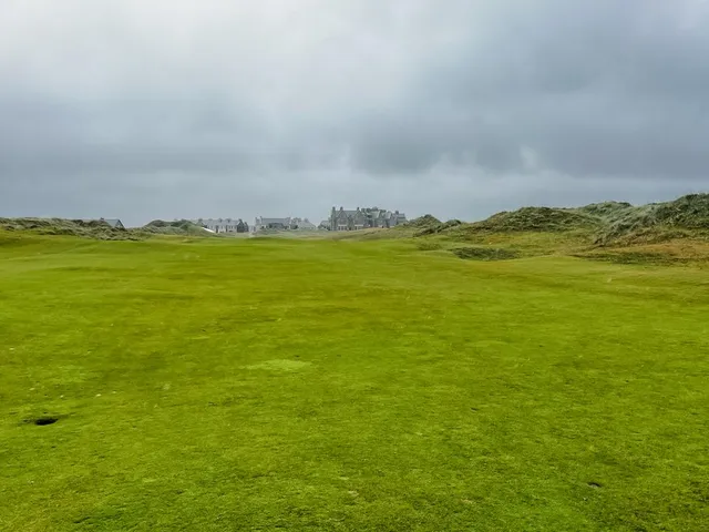A tee at Doonbeg looking down a fairway lined with dunes.