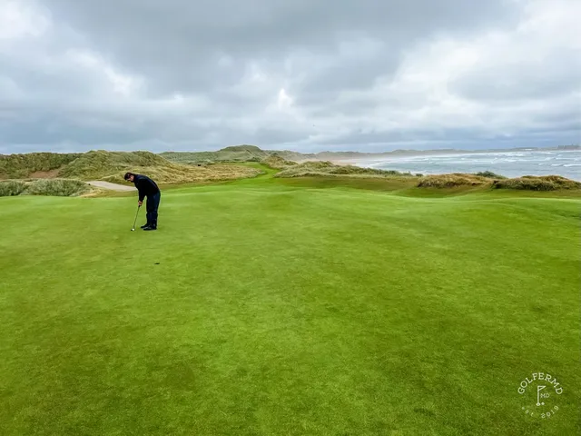 A fairway at Doonbeg with a bunker on the right and the bay ahead.