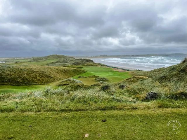 An elevated view across Doonbeg, fairways and bunkers in front of the ocean.