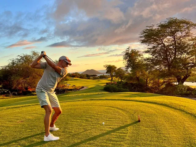 A fairway and green at the Emerald Course, with palm trees beside the hole and the Pacific beyond.