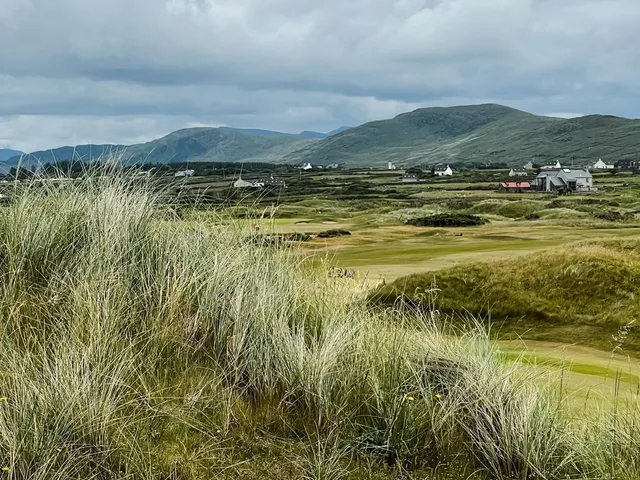 Golfers on a tee at Waterville, with the Atlantic and the mountains behind them.