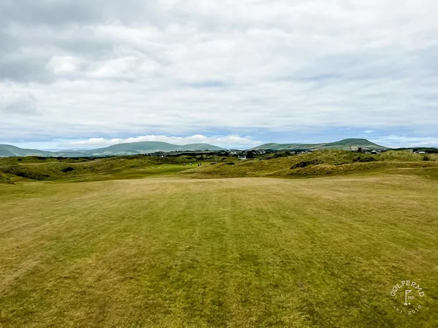 A close view of a flagstick at Waterville, with a bunker beside the green.