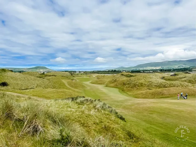 An elevated view across Waterville, fairways and bunkers in front of the ocean.