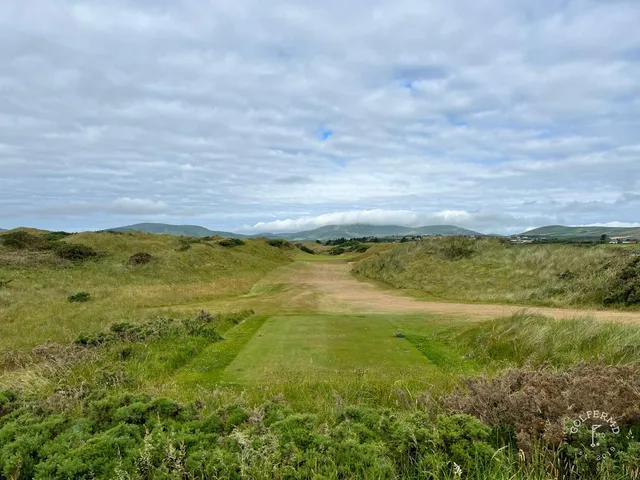 A close flagstick at Waterville, with the water just beyond the green.