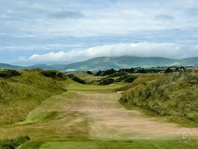 Golfers on a green at Waterville, with the Kerry mountains behind them.