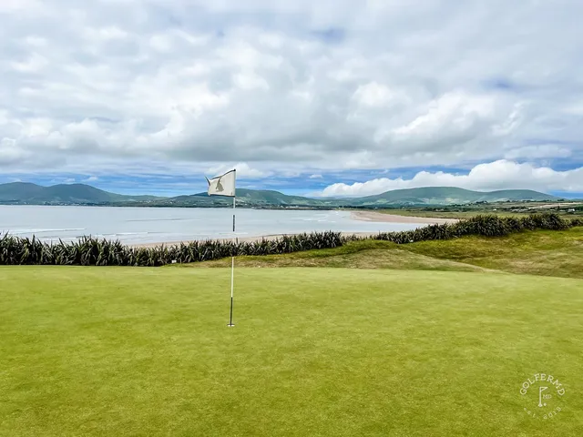 A green and bunker at Waterville, the flagstick against the ocean and the mountains.