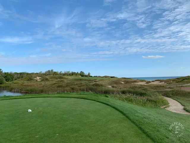 A tee on the Straits Course looking down a fairway lined with dunes.